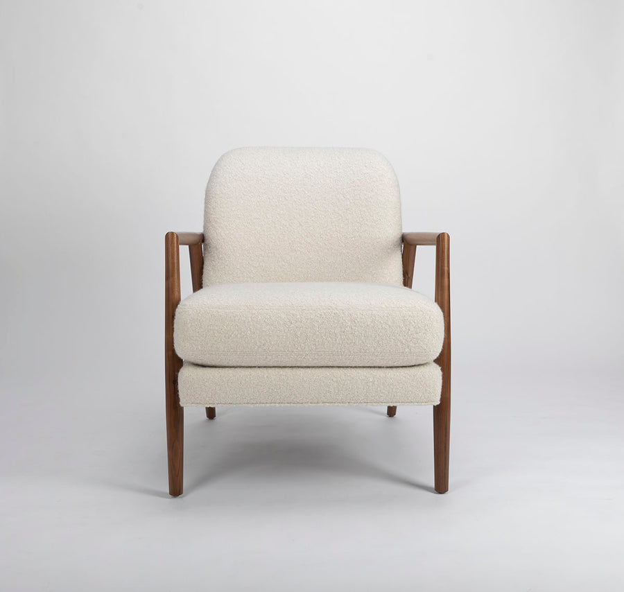 A white Lex lounge chair with solid maple frame, curved back. Front view.