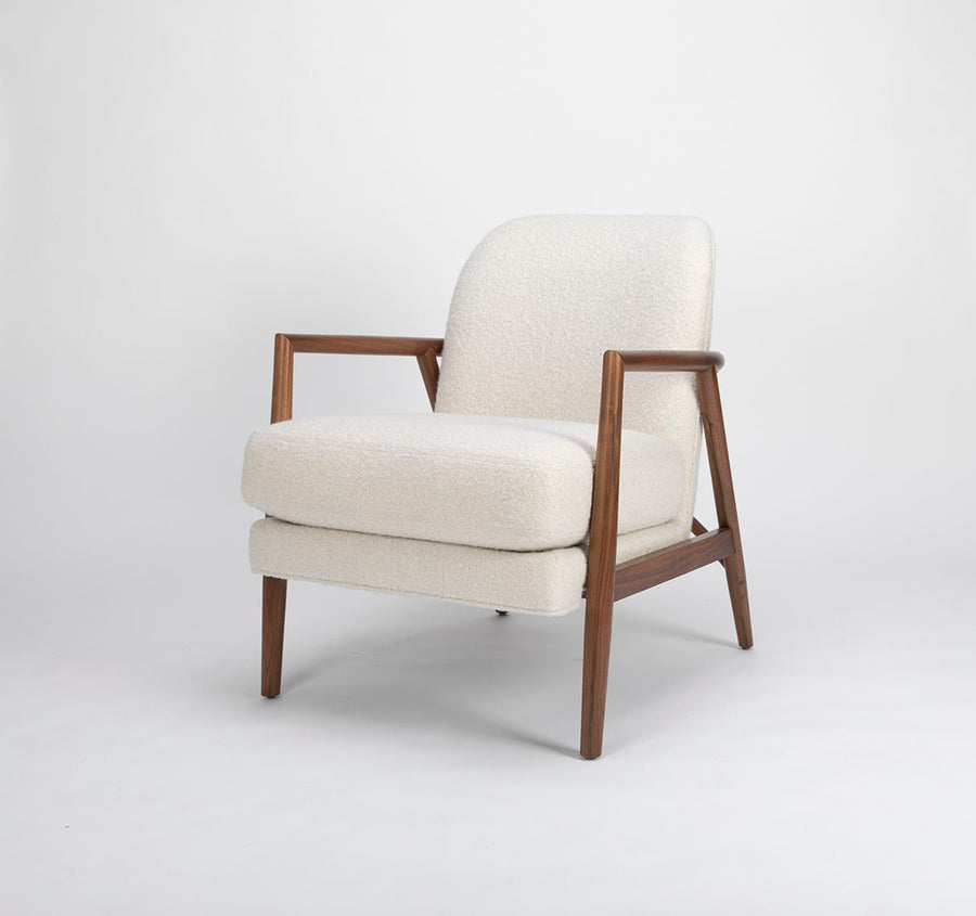 A white Lex lounge chair with solid maple frame, curved back. Front and side view.