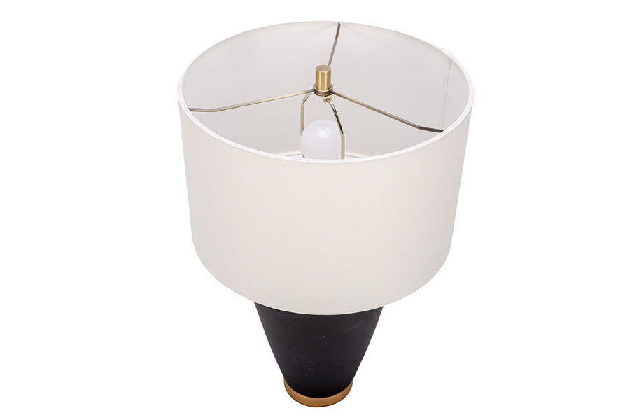 Gavin table lamp with a drum white shade and modern black ceramic body in an unique asymmetric design and a contrasting gold base. Closed up top view.
