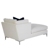A white Aiden Chaise with metal legs and a blue pillow on it, side back view.