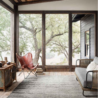 Amara Silver + Dark Grey Area Rug placed on a closed deck with vintage furniture.