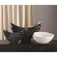 Spiral Bowl made of Portuguese ceramic with an matte white finish and a swirling ridge that spirals from the outer edges of the bowl towards the center. Placed with other decorative items.
