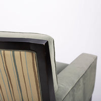 Curtis lounge chair in grey-green color with clean wood detail, softly splayed legs, and outside back framed by the wood trim, closed up back view.