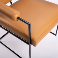 Classic modern leather dining chair designed in 1968 by Milo Baughman. Orange color with black metal frame.