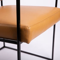 Classic modern leather dining chair designed in 1968 by Milo Baughman. Orange color with black metal frame.