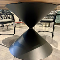 Fixed round Clessidra Dining Table with solid black steel base and wooden top. Closed up view on the steel base.