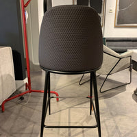 Black Lea counter stool with four-legs metal base and seat and backrest upholstered in hide. Back view.