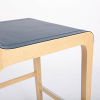 Tosca Barstool with blue leather seating and solid beechwood construction. Closed up bottom side view.