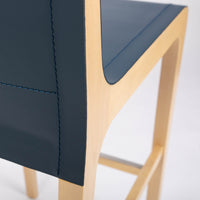 Tosca Barstool with blue leather seating and solid beechwood construction. Closed up back side view.