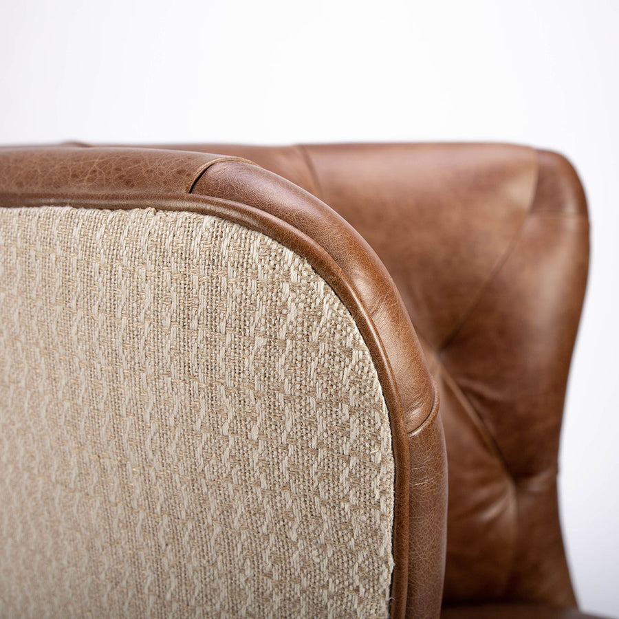 Goodman brown leather chair with curved back, textured woven fabric outside back. Closed up back and top view.