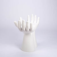 Sculptured stool that looks like two hands with opened palms for seating area made in white matte finish.