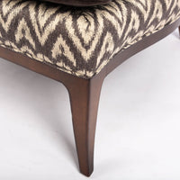 Beautifully shaped brown armless lounge chair with a curved back and seat rail, and saber shaped legs. Closed up bottom view.