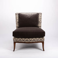 Beautifully shaped brown armless lounge chair with a curved back and seat rail, and saber shaped legs. Front view.