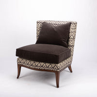 Beautifully shaped brown armless lounge chair with a curved back and seat rail, and saber shaped legs. Front and side view.