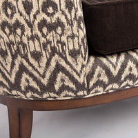 Beautifully shaped brown armless lounge chair with a curved back and seat rail, and saber shaped legs. Closed up bottom view.
