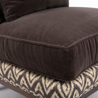 Beautifully shaped brown armless lounge chair with a curved back and seat rail, and saber shaped legs. Closed up seat view.