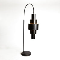 Black Babylon Floor Lamp with formed of bold concentric circles and with floor switch on cord. Closed up view on bronze finish and lamp.