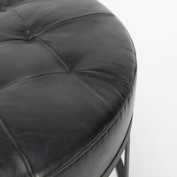 Tufted round ottoman by Cisco Brothers in top navy leather. Closed up view.