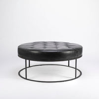 Tufted round ottoman by Cisco Brothers in top navy leather.