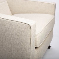 A white fabric Tate recliner lounge chair with stainless steel base, closed up side view.