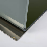 Two-toned bent glass coffee table with glued mat stainless steel plate. Closed up view on a steel plate.