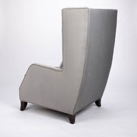 A light grey Rob lounge chair with extra high back, subtle angles and clean shape in the wing detail, side and back view.