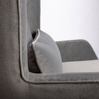 A light grey Rob lounge chair with extra high back, subtle angles and clean shape in the wing detail, closed up side view.