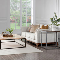 Avant Cocktail Table built with a solid steel base and solid wood top, placed in a room with a sofa and side table.