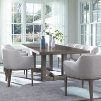 Axis Dining Table placed in a modern dining room with 6 white chairs and 3 vases with flowers on top of it.