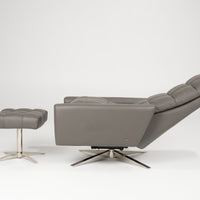 A reclined grey leather Huron recliner and lounge chair with natural walnut four-star base and ottoman.