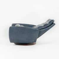 A blue Lanier leather recliner chair with the shape of classic automotive designs, reclined, side view.