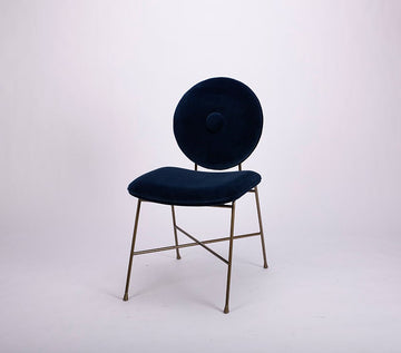 A blue Penelope side dining chair with the round back and large button detail combined with the saddle seat.