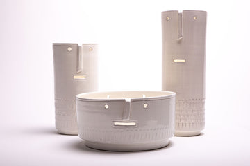 Three Modigliani inspired Mod Face bowls molded of glossy white ceramic.