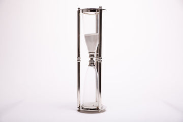 Exquisitely formed sand clock with the glass vessels that hold sand that measure out one full hour. Metal frame complete with rubber washers hold and support the glass vessels.