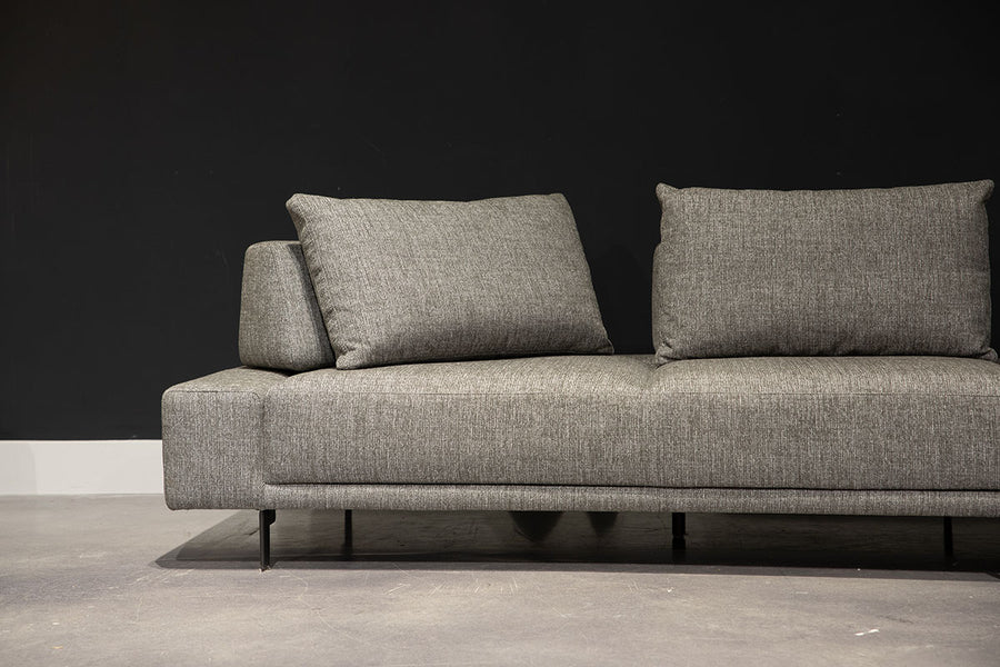 Grey fabric Felix Sectional with moveable back and arm rests and metal legs. Partial view of the left side.