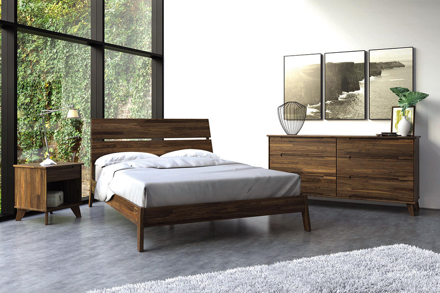 Linn queen size bed crafted from reclaimed walnut hardwood with contemporary design, side view, with bedside table, placed in a well light room.