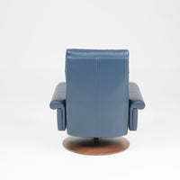 A blue leather Nimbus recliner chair with a disc base in Natural Walnut. Back view.