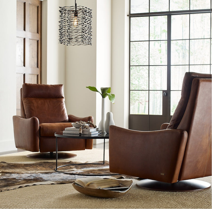 Two brown leather Ontario modern rocking recliner chairs.
