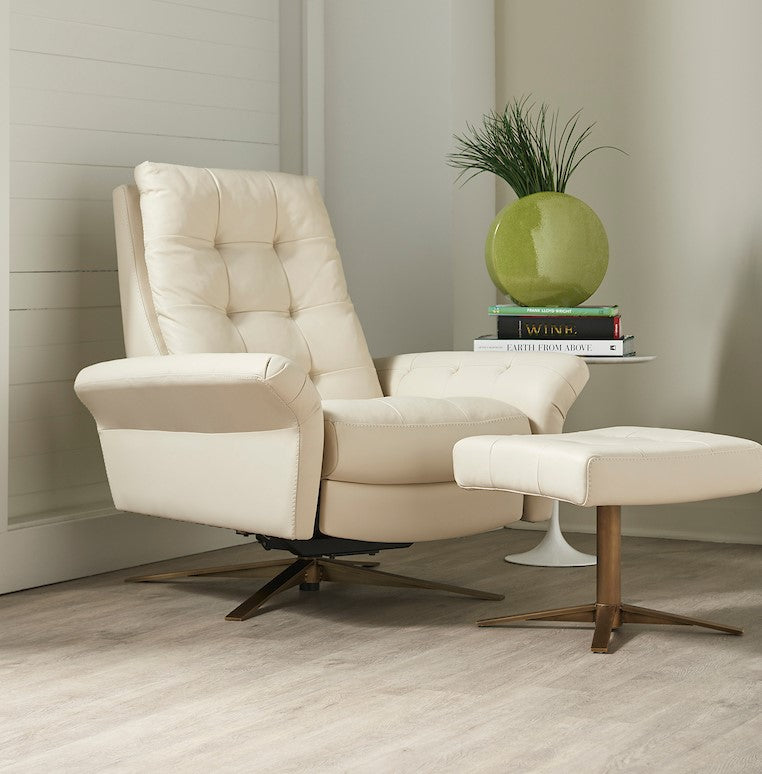 A white leather recliner chair with buttonless tufted back and seat and four star base and ottoman.