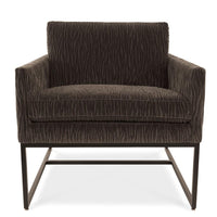 A brown Rebel lounge chair with angled side profile and metal frame, front view.