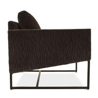 A brown Rebel lounge chair with angled side profile and metal frame, side view.