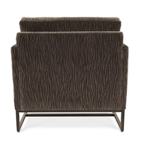 A brown Rebel lounge chair with angled side profile and metal frame, back view.