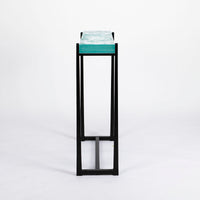Cooper Console with subtle tapered legs and green facet glass top, side view.