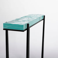 Cooper Console with subtle tapered legs and green facet glass top, closed up side view.