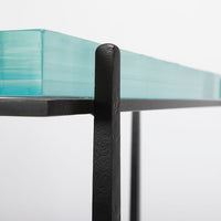 Cooper Console with subtle tapered legs and green facet glass top, closed up side view.
