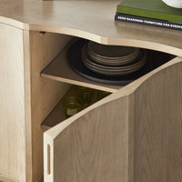 Partial view of Jarvis storage cabinet with one door opened to show items placed inside.