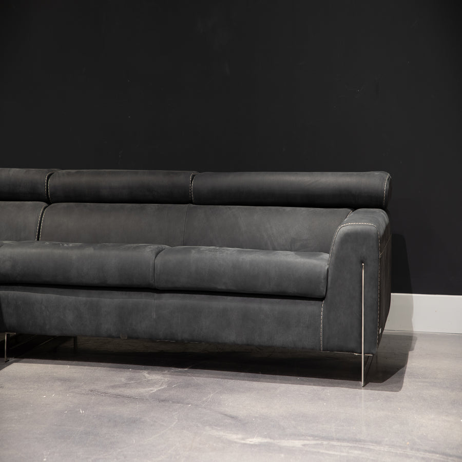 Black leather Bellevue Sectional with minimal lines and an original metal base that slots into the armrests. Left part view.