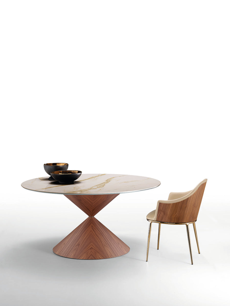 Fixed round Clessidra Dining Table with solid wooden steel base and wooden top, with two black bowls on it and a matching chair on it's right side.