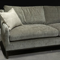 Grey two seat Fisher sofa with soft curved outside back, wood perimeter detail and casual comfort.