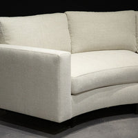 White curved Clip Sectional with the wood legs. Closed up side view.